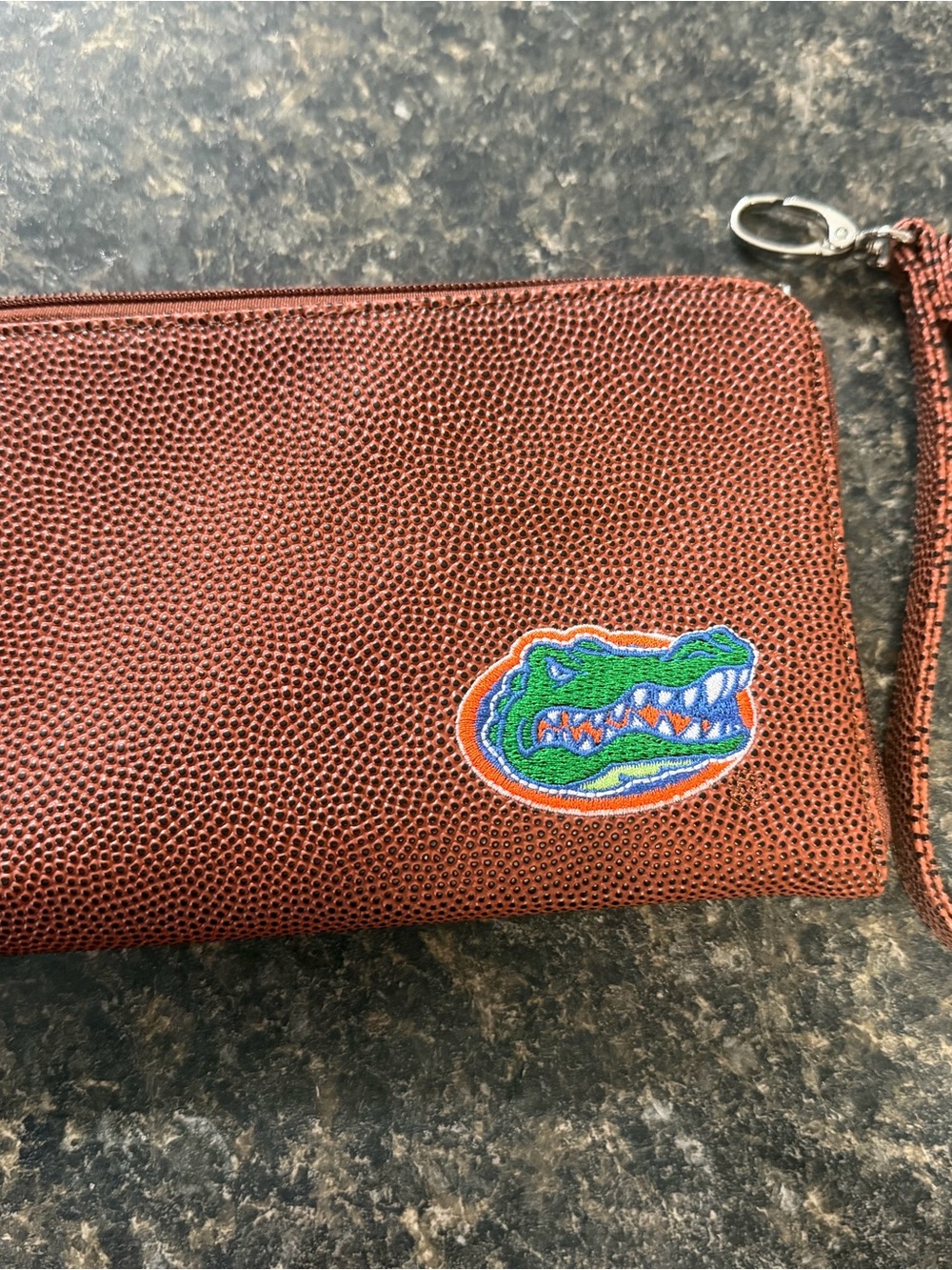 New brown texture wristlet featuring an embroidered Florida Gators team logo